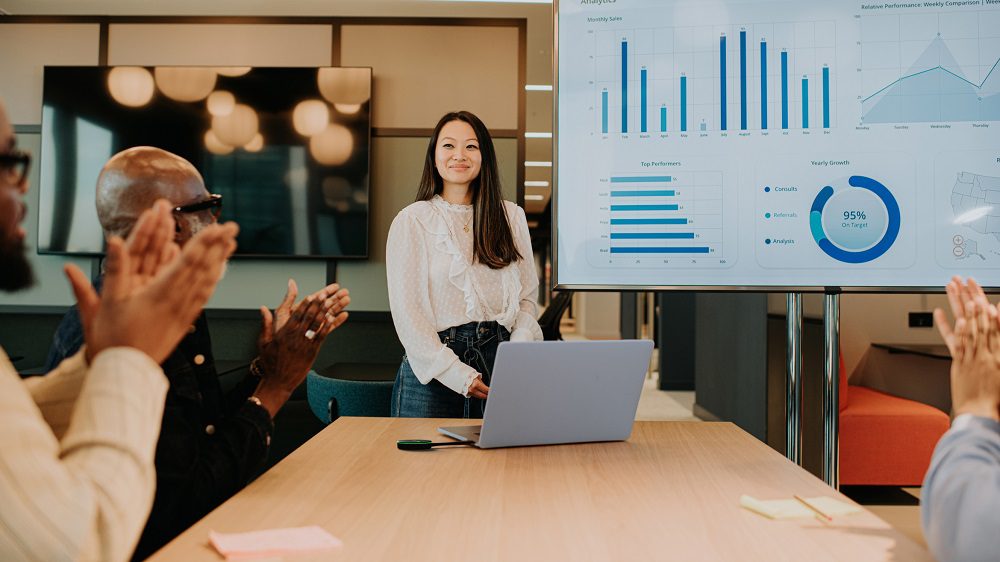 Woman giving presentation in hybrid work environment.