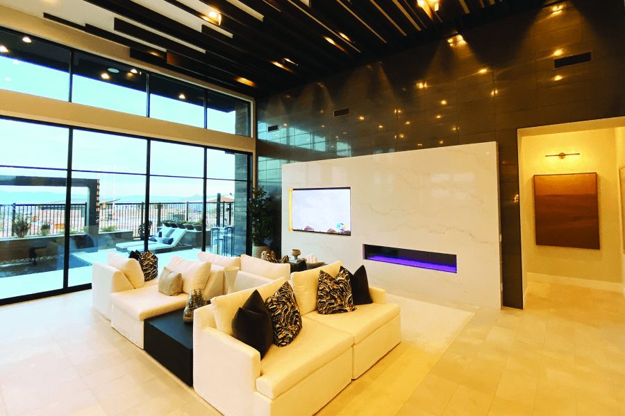 Interior modern warmly lit living space television and fireplace.