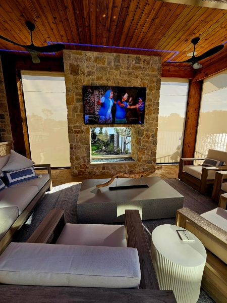 Outdoor entertainment and living space decorated with ceiling fans and hemmed in by sheer shade solutions