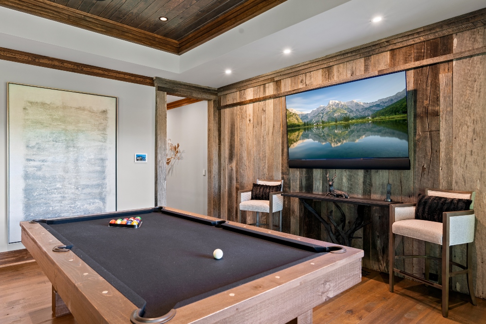 Cozy game room with billiard table and natural wood accents along the wall