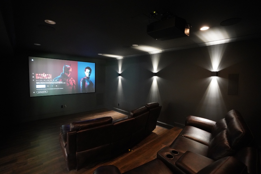 Small bespoke home theater with projector system featuring Robert Pattinson as the Batman on the main screen